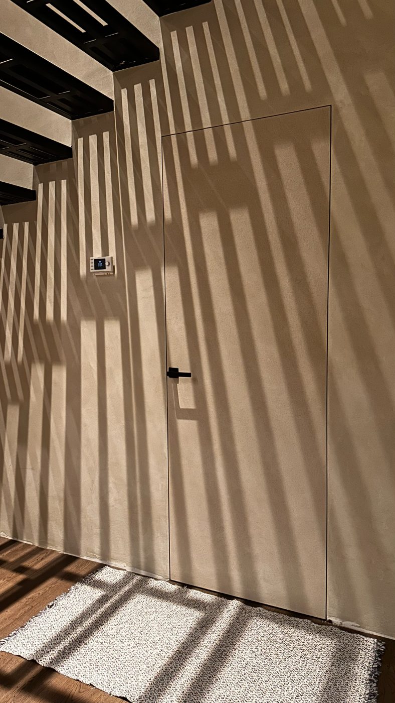 AST22 peituksega koridor — ribikardinate vari mängib pahteldatud seinal